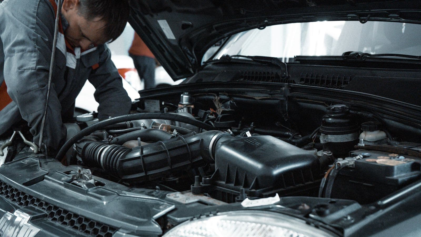 Mécanicien inspectant le moteur d'une voiture avant contrôle technique